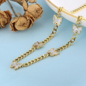 Detail showing golden butterfly charms with white shell inlay on a link chain necklace