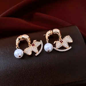 Macro de boucles d'oreilles cheval plaquées or 18K avec perle et strass étincelants
