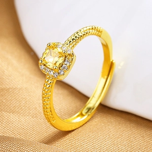 Close-up of heart-shaped opal open ring with twisted gold band and yellow gemstone