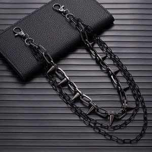 Detail of punk gunmetal pants chain with metallic spikes and multi-layered rock design