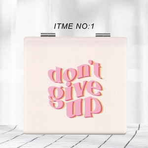 Close-up of portable square light pink leather folding mirror with don't give up text