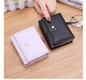 Detailed view of compact tri-fold wallets in black and lilac with heart metal accents