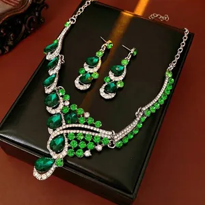 Elegant vintage jewelry set with teardrop emerald stones and diamond-studded necklace