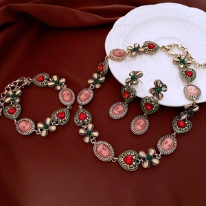 Detailed view of vintage cameo jewelry set with heart and clover charms on silk