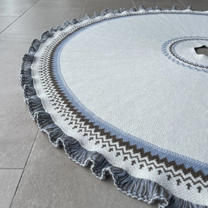 Close-up of Fair Isle knitted Christmas tree skirt with blue patterns and fringe edge