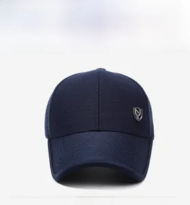 Détail de la casquette marine en maille avec emblème métallique sur tissu respirant
