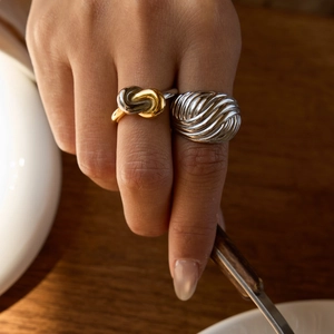 Detailed view of silver threaded ring and two-tone cable ring worn on fingers