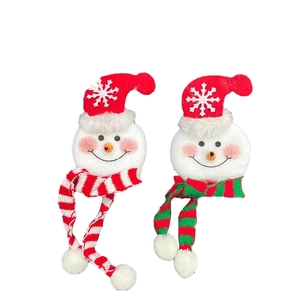 Plush Christmas snowman decorations with striped scarves and red hats on white background