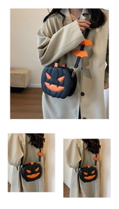 Detail of pumpkin face on black crossbody bag with decorative bat wings on shoulder strap