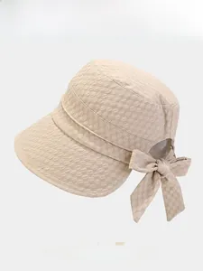 Detail of light beige sun hat showing bubble texture fabric and stylish bow accent