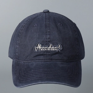 Nahaufnahme einer dunkelblauen Baseballkappe mit Abundant-Textstickerei auf der Front.