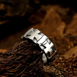 Close-up of vintage engraved silver ring with floral patterns on rustic wood background