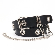 Detail of a slim black PU belt with silver metal eyelets and a detachable punk style chain