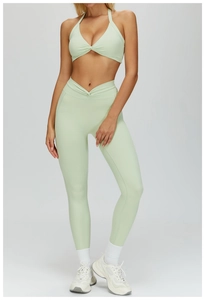 Detail of high-waist yoga pants with V-shaped twist knot in mint green sports fabric