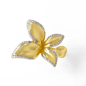 Detailed close-up of 18k gold butterfly ring with pave-set white zircons on leaves