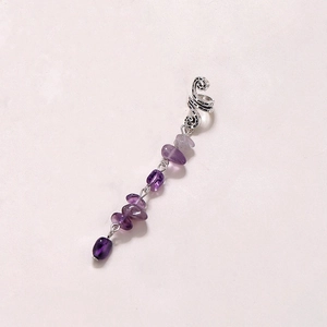 Detail of silver spiral ear cuff featuring hanging purple faceted natural stone tassels