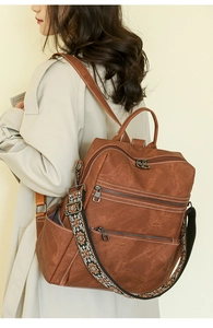 Brown vintage backpack with ethnic patterned strap and multiple zipper pockets
