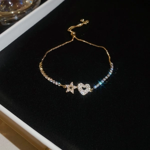 Detail of adjustable star and heart bracelet with cubic zirconia on black velvet