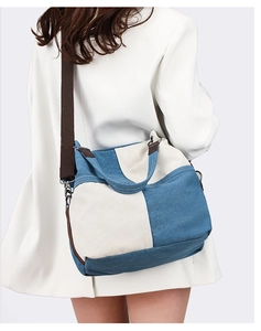 Detail of blue and beige canvas tote bag with adjustable wide strap and metal buckles