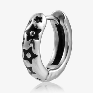 Detail of vintage stainless steel huggie earring featuring black enamel star patterns