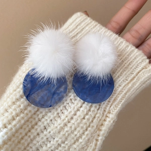 Winter plush ball drop earrings with blue marble resin discs on soft sweater fabric