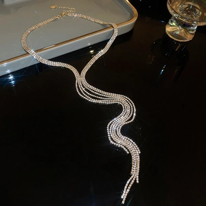 Macro view of gold fringe necklace with sparkling white rhinestones and layered design