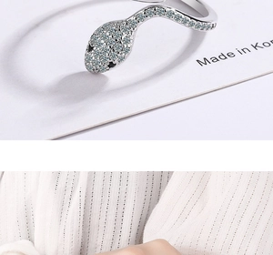 Detailed view of silver snake ring with pavé-set gemstones and black jewel eyes