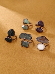 Detailed close-up of natural raw gemstones set in adjustable antique copper rings