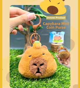 Detail of cute capybara plush keychain featuring an orange decoration and zipper coin pocket