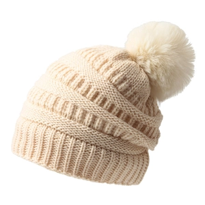 Bonnet en tricot crème avec pompon duveteux et maille torsadée sur fond blanc
