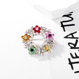 Detailed close-up of a colorful crystal flower wreath brooch with vibrant rhinestones