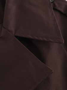 Detailed view of dark brown lapel collar and fine stitching on short trench coat