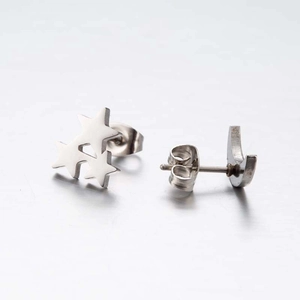 Macro view of silver asymmetric star and moon stud earrings with secure metal backs
