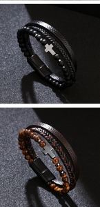 Detailed view of layered leather bracelets with cross charm and tiger eye stones