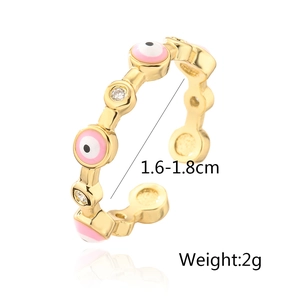Macro detail of gold-plated evil eye ring with pink enamel and sparkling zircon accents