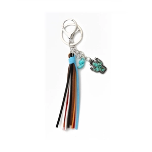 Detail of western style keychain featuring colorful leather tassels and turquoise cactus charm