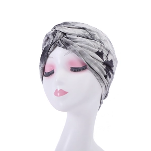 Close-up of black and white tie-dye turban hat on a mannequin head with marble pattern
