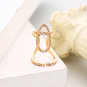 Detail of gold zircon nail ring featuring a double oval hollow design on white stand