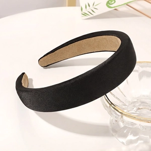 Detail view of a thick black satin sponge headband with khaki non-slip velvet inner lining