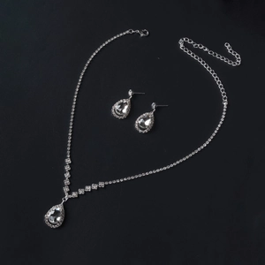 Detailed view of silver bridal necklace and drop earrings set with sparkling rhinestones