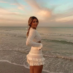 Women's sexy white knit two-piece set featuring long sleeve crop top and ruffle shorts