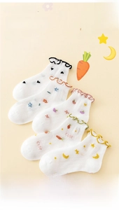 Detail of five pairs of white cotton mesh socks with colored frilly edges and cute embroidery