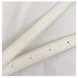 Macro detail of white leather strap showing precise stitching and adjustable punch holes
