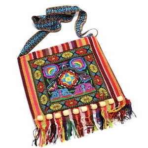 Detailed embroidery on ethnic shoulder bag with wooden beads and colorful tassels