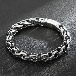 Close-up of a silver vintage men's stainless steel heavy link chain bracelet on a black surface
