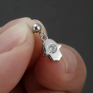 Macro shot of a 316L stainless steel Hamsa hand pendant stud with a clear crystal gemstone