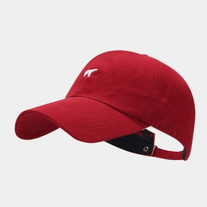Detail of red cotton baseball cap featuring white polar bear embroidery and curved brim