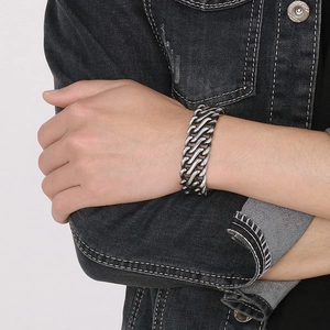 Close-up of men's retro silver braided stainless steel chain bracelet on a male wrist