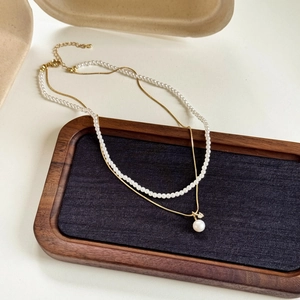 Detailed view of 18k gold plated double layer necklace with pearls and zircon pendant