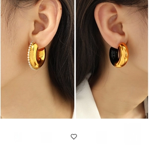 Detail of C-shaped metal hoops with crystal inlay and gold-black contrast finish
